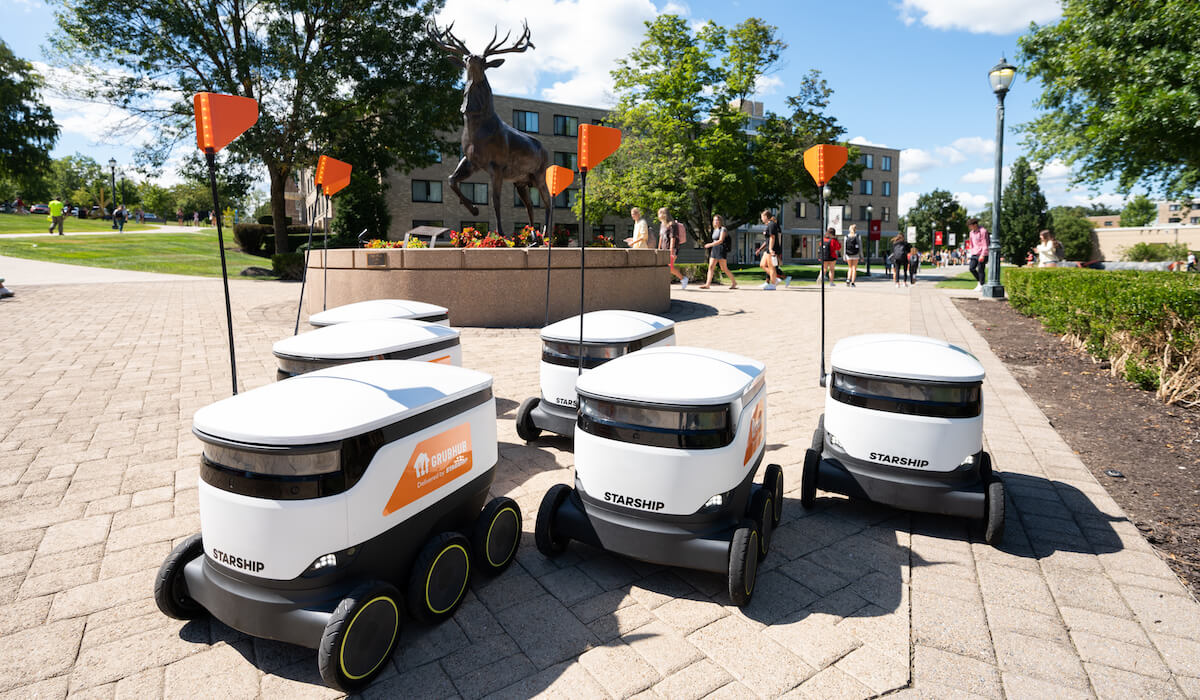 A group of self driving robots traveling across a college campus.