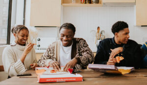 Three students enjoying a pizza on campus.